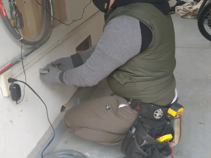 Electrician performing outlet wiring in a Williston garage